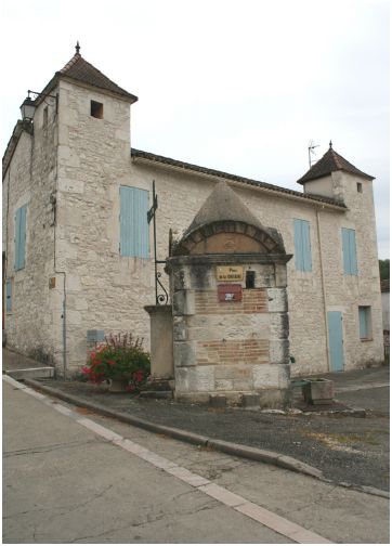 La Fontaine, devant une maison quercynoise traditionnelle